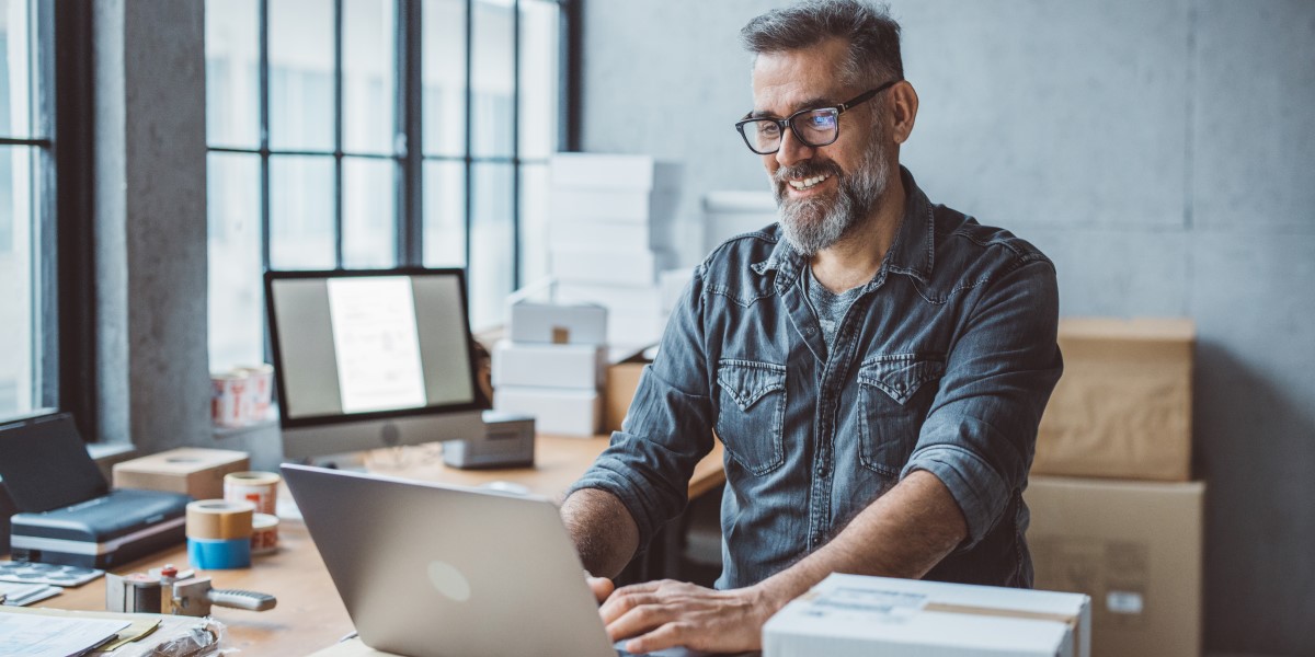 Man on laptop with boxes in background